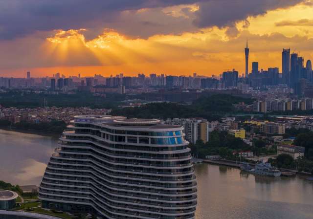 8月I6日，广州生物岛，光束透过云层照向城区建筑。南方+拍客   陆建生 摄